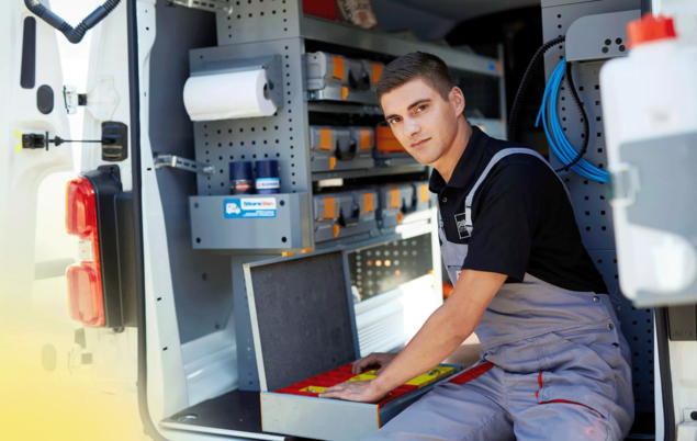 Junger Arbeiter in einem Lieferwagen